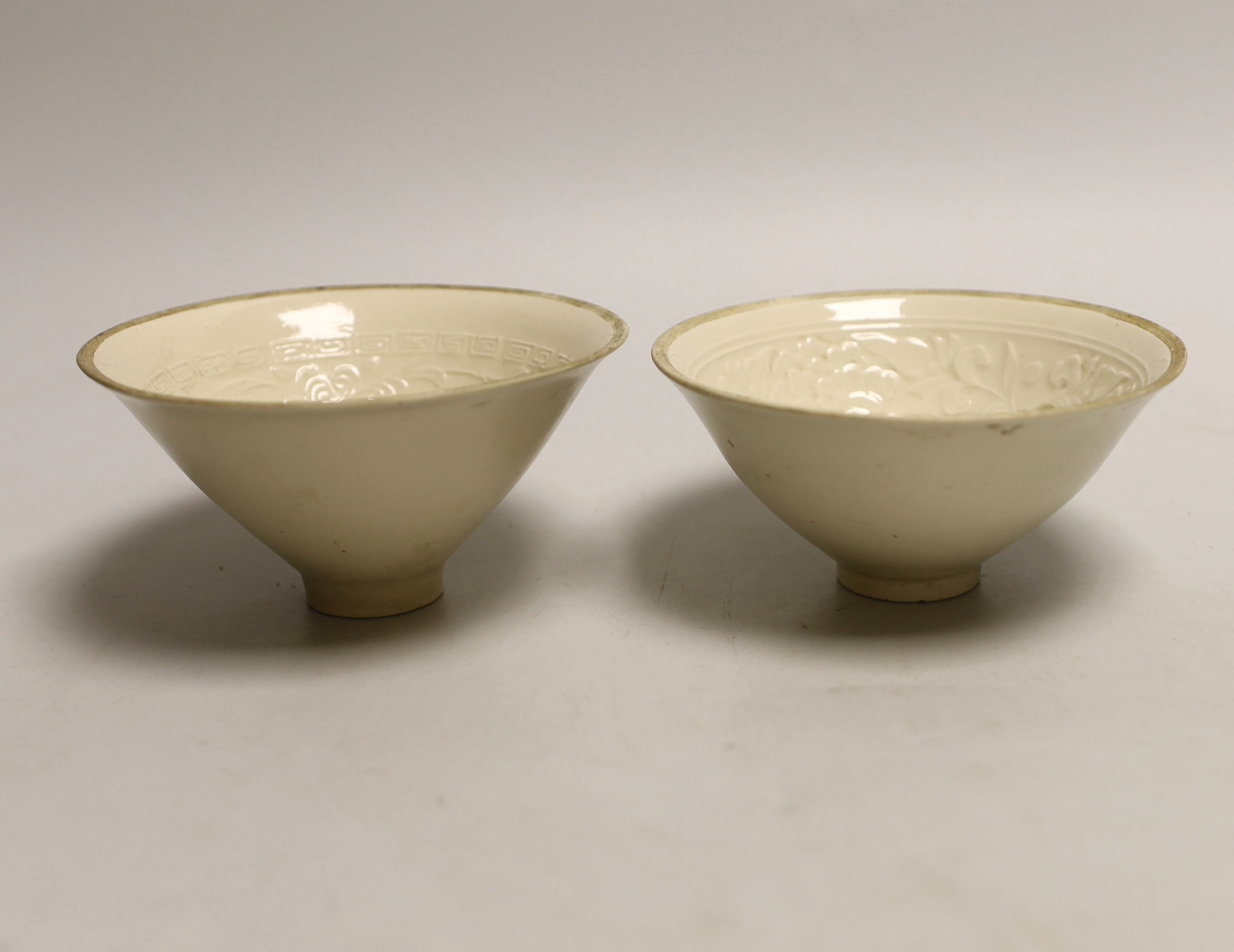 A pair of Chinese Ding type relief moulded bowls, 12cm in diameter